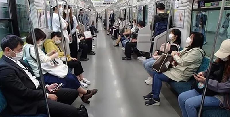 電車内でマスクする人々