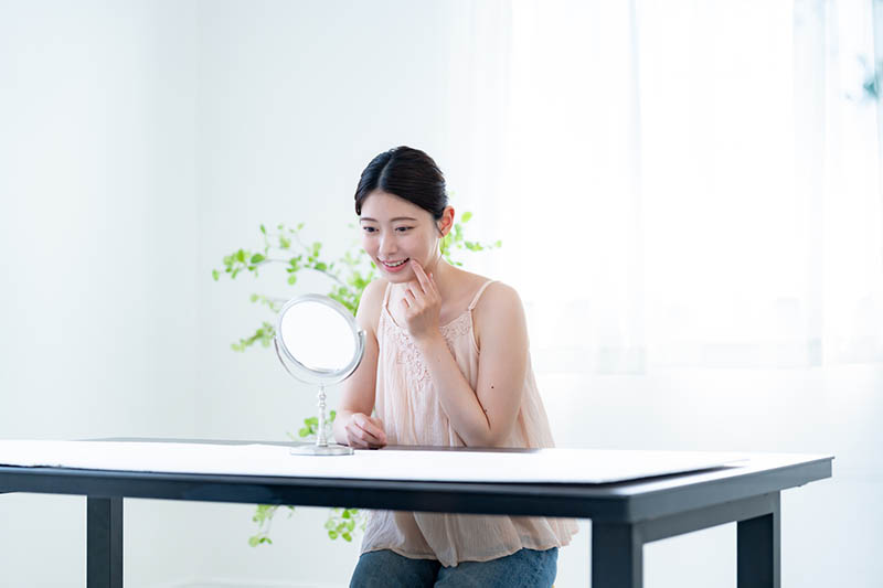 口に手をあてる女性